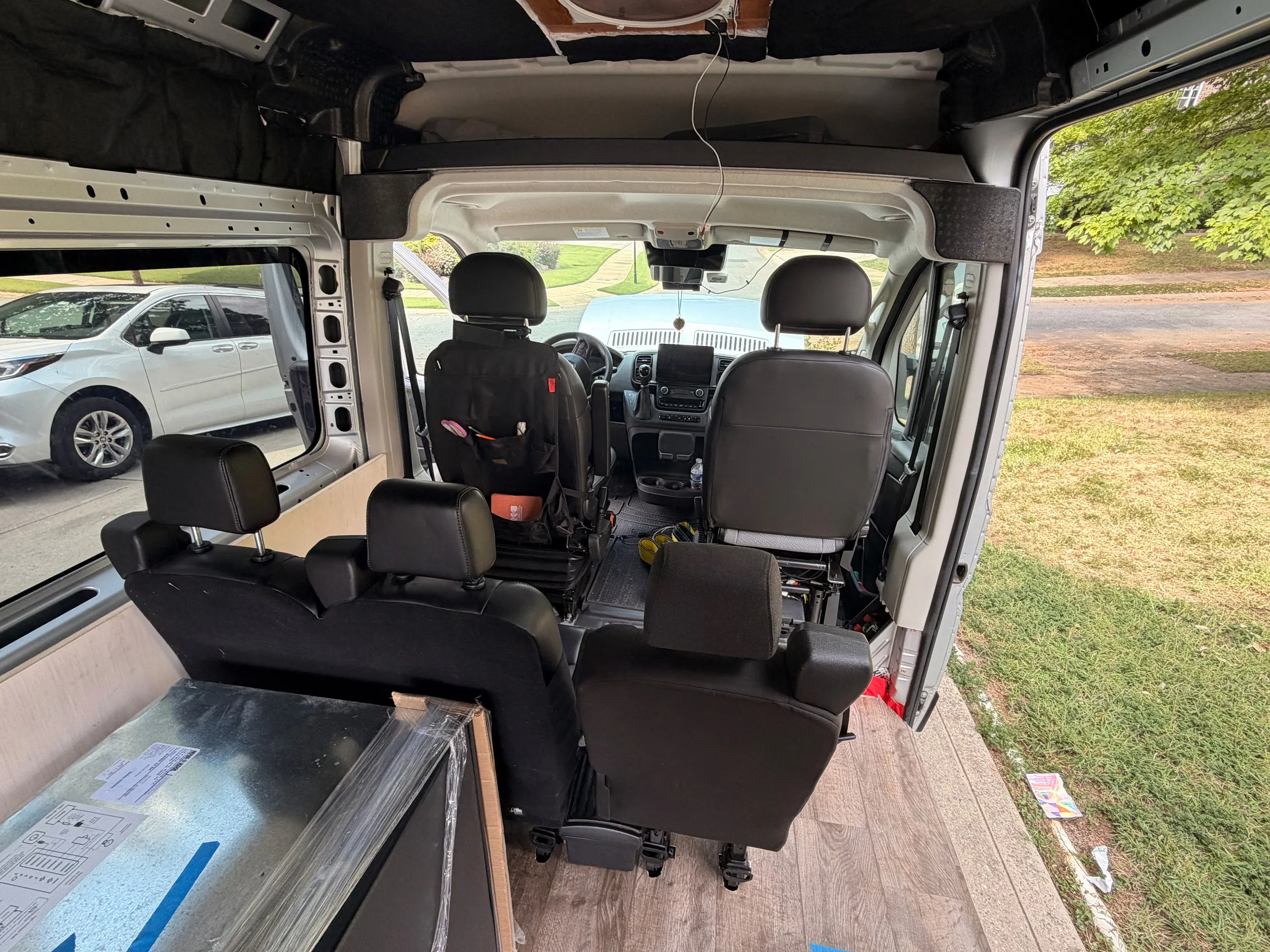 View forward from the cargo area toward the cab, with three rear passenger seats and the two front seats