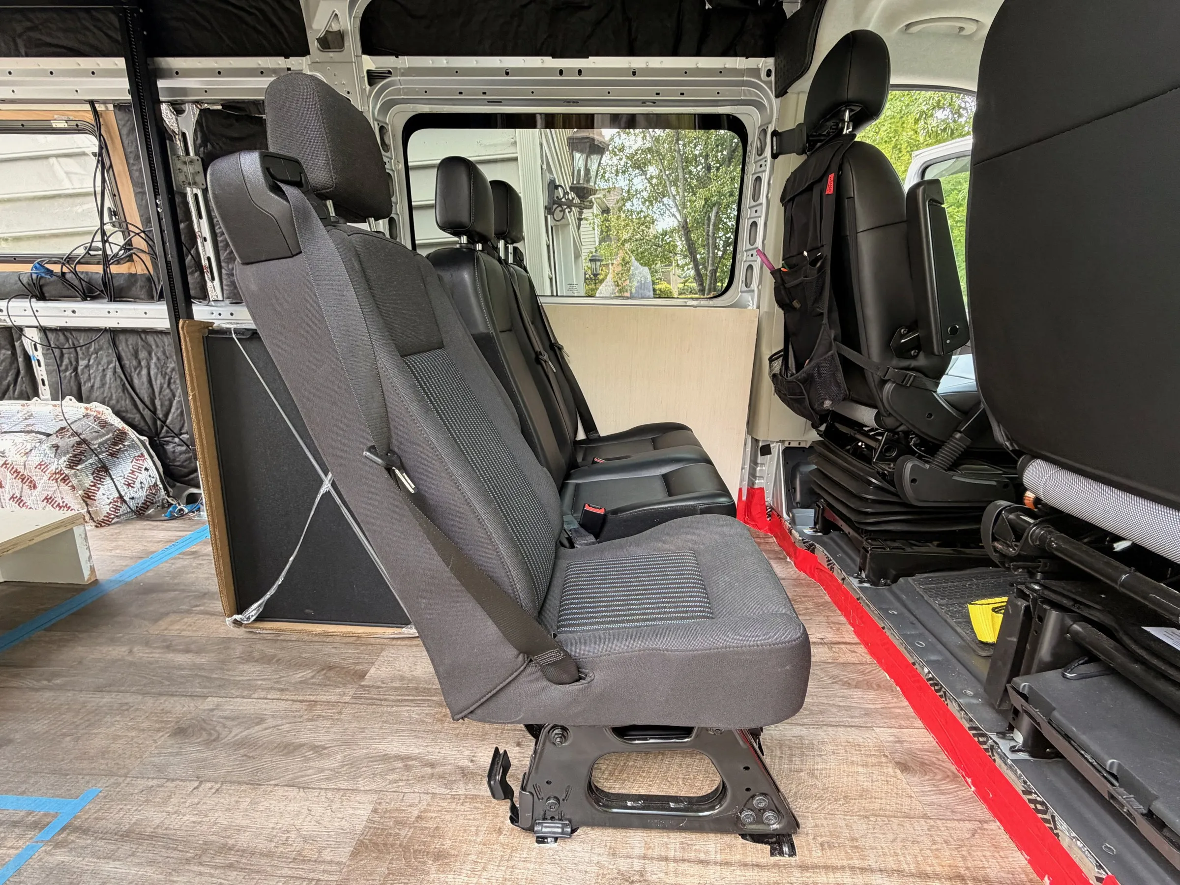Removable rear passenger seats, one fabric single and one black leather double, on wood-look plank flooring