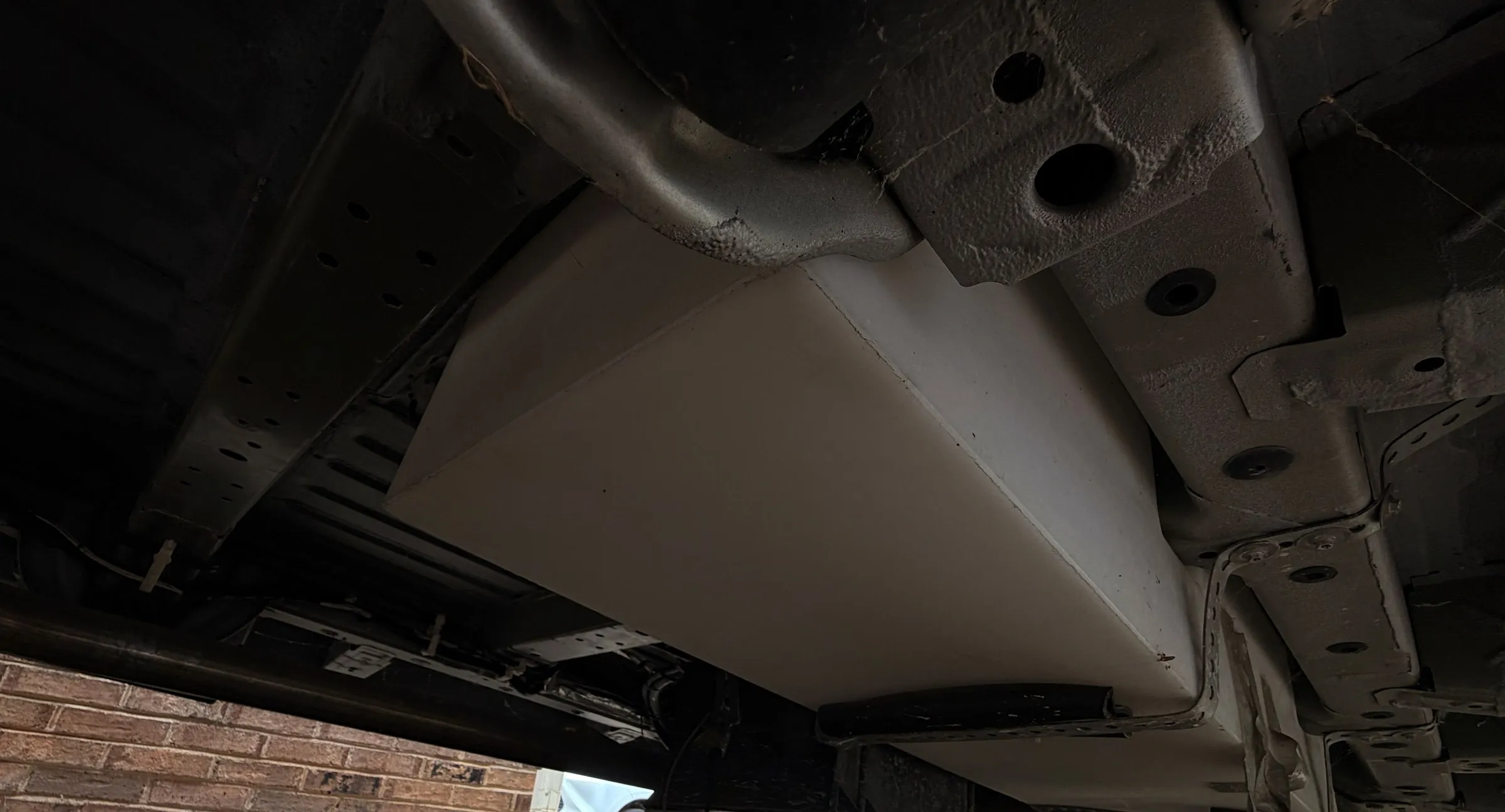 Underside of the van showing a white tank mounted to the chassis